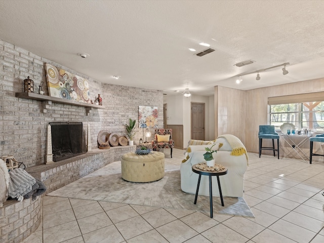 12580 Briar Rd, Azle, TX 76020 - living area featuring light tile patterned flooring, a textured ceiling, a fireplace, and rail lighting