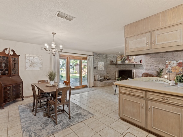 12580 Briar Rd, Azle, TX 76020 - dining space with a chandelier, light tile patterned flooring, a textured ceiling, and a brick fireplace