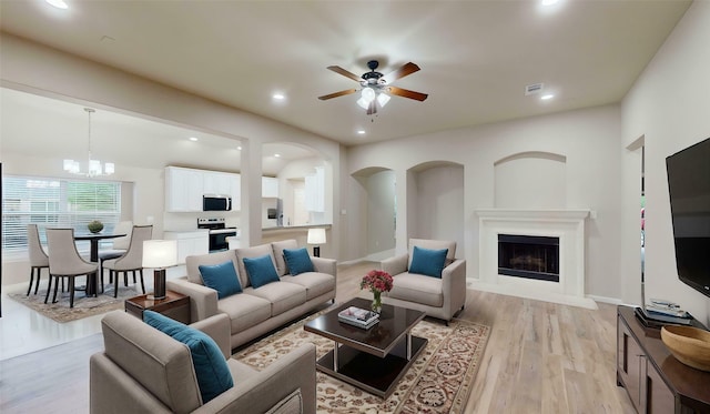 760 Catalpa Rd, Saginaw, TX 76131 - living area featuring a ceiling fan, recessed lighting, a fireplace with raised hearth, light wood finished floors, and a chandelier