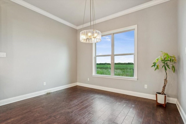 empty room featuring baseboards, ornamental molding, dark wood finished floors, and a chandelier