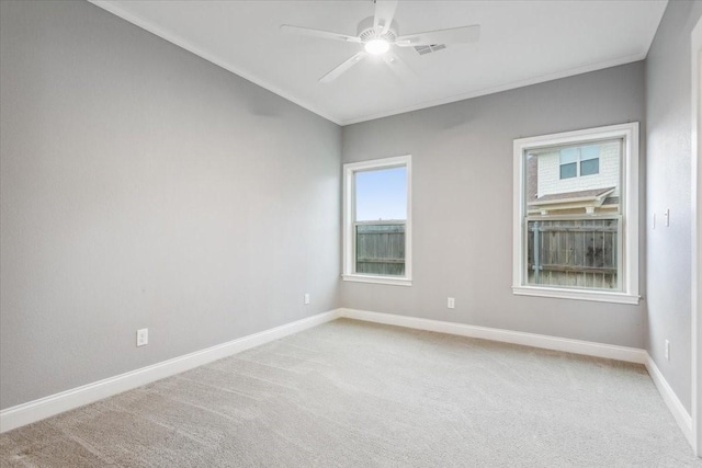 unfurnished room with crown molding, a ceiling fan, baseboards, and light carpet