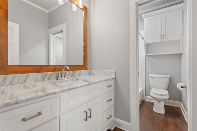 bathroom featuring crown molding, vanity, wood finished floors, toilet, and baseboards