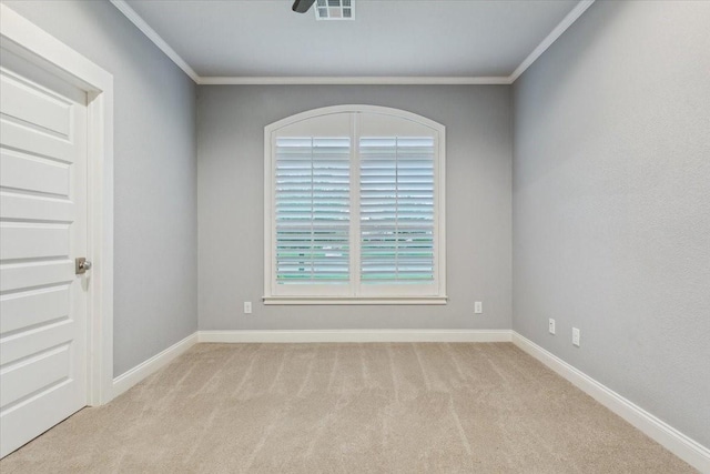 empty room with crown molding, baseboards, and carpet