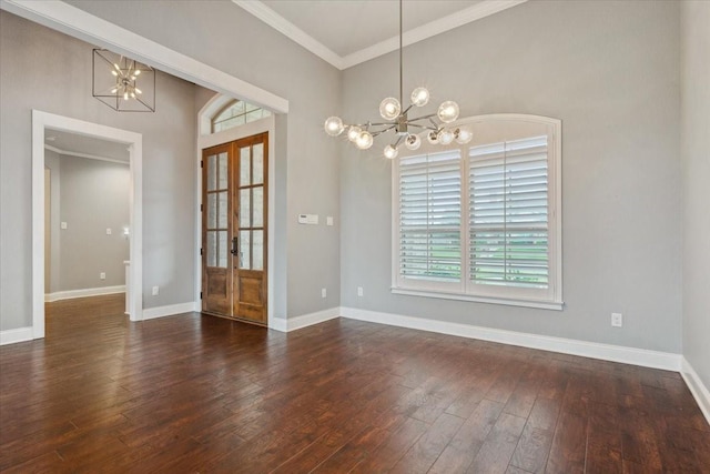unfurnished dining area featuring crown molding, a notable chandelier, wood-type flooring, french doors, and baseboards