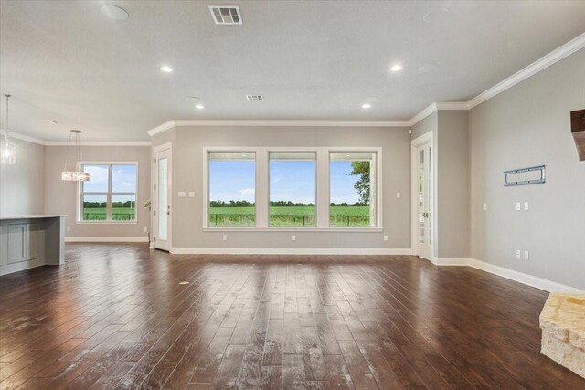 unfurnished living room featuring baseboards, visible vents, an inviting chandelier, and dark wood-type flooring