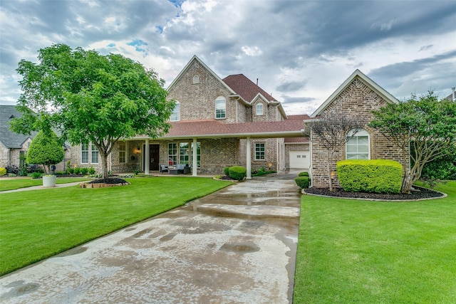traditional home featuring a garage, a front lawn, brick siding, concrete driveway, and a porch