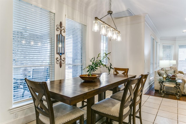 dining area featuring baseboards, ornamental molding, and light tile patterned floors