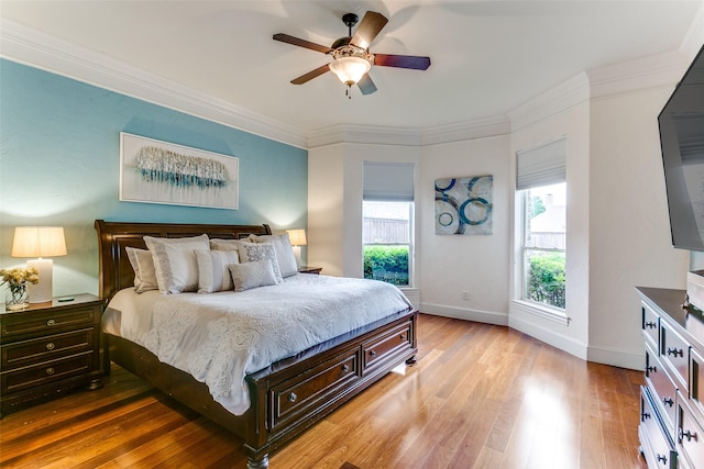 bedroom featuring crown molding, baseboards, ceiling fan, and light wood-style floors