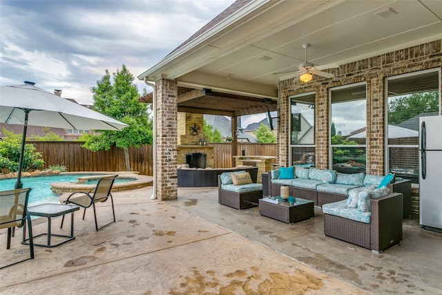 view of patio / terrace with visible vents, an outdoor living space with a fireplace, a fenced backyard, an in ground hot tub, and a ceiling fan