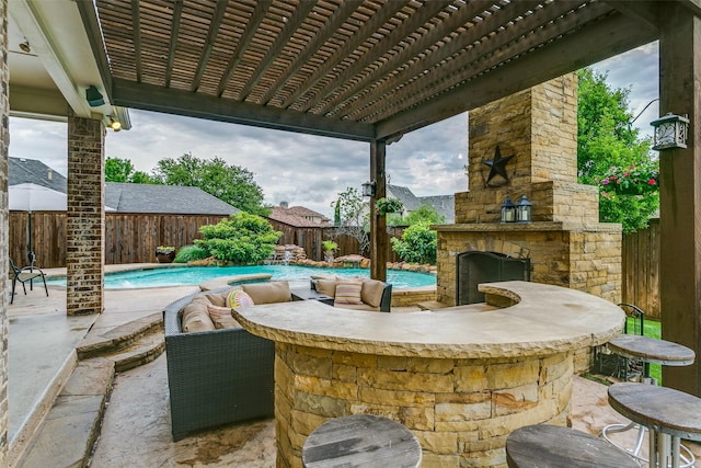view of patio / terrace featuring an outdoor stone fireplace, a fenced in pool, and a fenced backyard