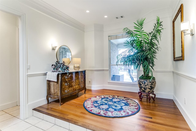 living area with visible vents, ornamental molding, wood finished floors, baseboards, and recessed lighting
