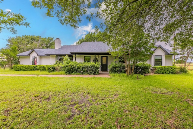 ranch-style house featuring a chimney and a front yard