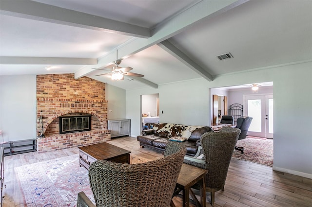 living room with a ceiling fan, visible vents, lofted ceiling with beams, and wood finished floors