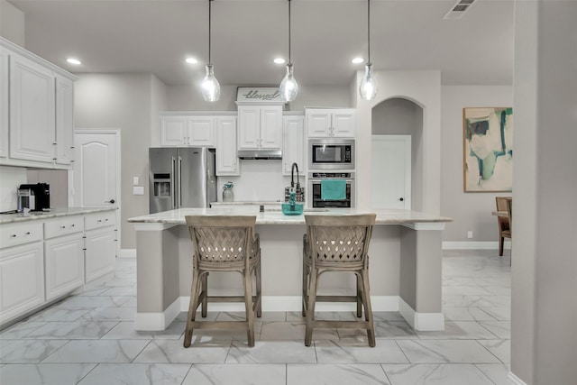 kitchen featuring baseboards, recessed lighting, marble finish floor, and appliances with stainless steel finishes