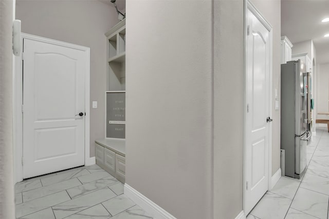 hallway with baseboards, recessed lighting, and marble finish floor