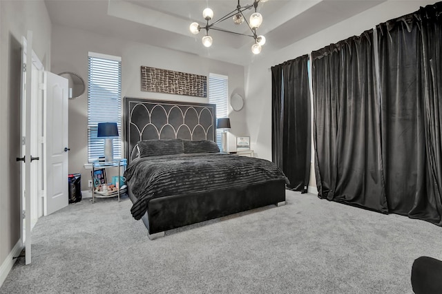 bedroom featuring carpet floors, baseboards, an inviting chandelier, and multiple windows