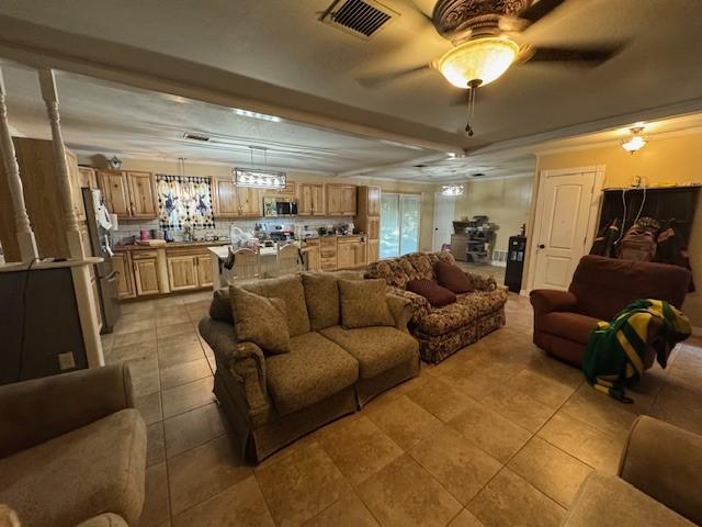 405 E Lee St, Rotan, TX 79546 - living area with light tile patterned flooring, a ceiling fan, and visible vents