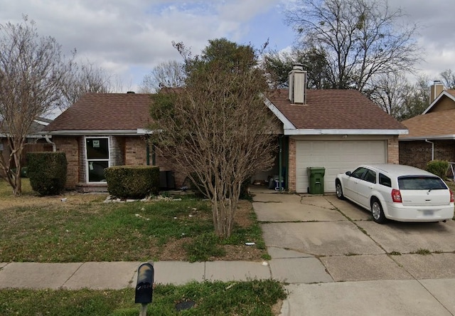 view of front of property featuring a chimney, brick siding, a garage, concrete driveway, and a front lawn