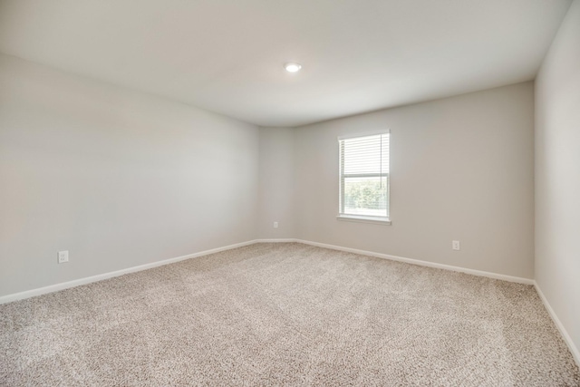 spare room featuring carpet flooring and baseboards