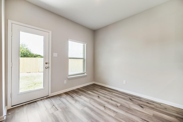 entryway featuring baseboards, a healthy amount of sunlight, and wood finished floors