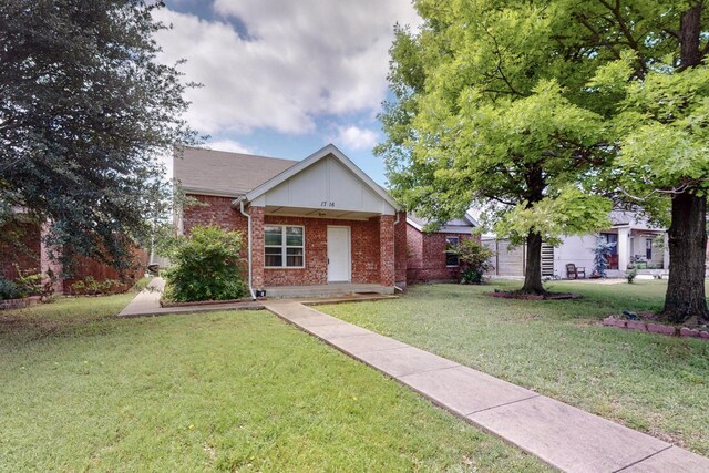 view of front of property featuring brick siding and a front lawn