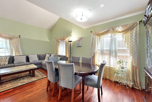 dining area with healthy amount of natural light, dark wood-type flooring, and lofted ceiling