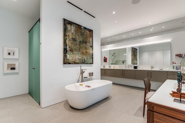 bathroom featuring a freestanding bath, vanity, tile patterned floors, a shower with door, and recessed lighting