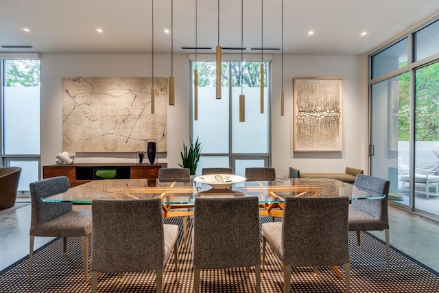 dining room with concrete flooring, recessed lighting, and a healthy amount of sunlight