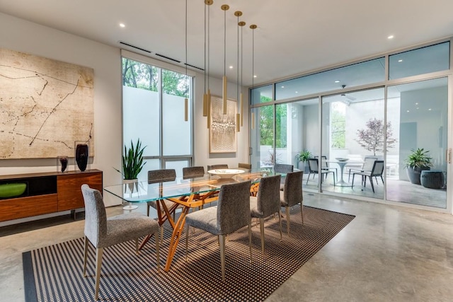 dining room with floor to ceiling windows, concrete flooring, and recessed lighting
