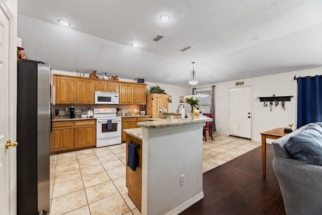 8121 Kathleen Dr, Fort Worth, TX 76137 - kitchen featuring brown cabinetry, white appliances, light tile patterned floors, and visible vents
