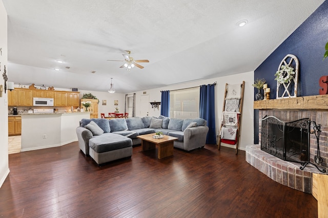 8121 Kathleen Dr, Fort Worth, TX 76137 - living room with dark wood-style flooring, a ceiling fan, vaulted ceiling, and a brick fireplace