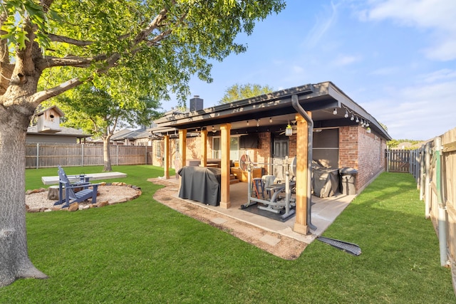 8121 Kathleen Dr, Fort Worth, TX 76137 - back of property featuring a yard, brick siding, a fenced backyard, and a patio