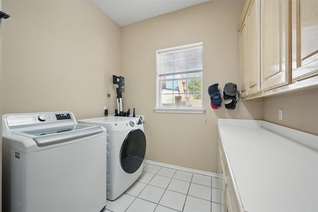 washroom featuring cabinet space, washer and clothes dryer, baseboards, and light tile patterned floors