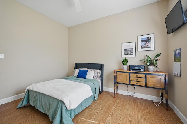 bedroom featuring wood finished floors, baseboards, and a ceiling fan