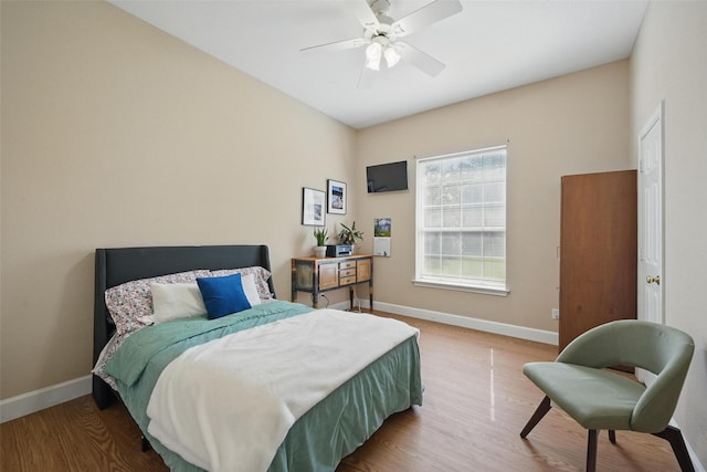bedroom featuring wood finished floors, baseboards, and a ceiling fan