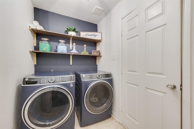 washroom with laundry area, independent washer and dryer, light tile patterned floors, and visible vents