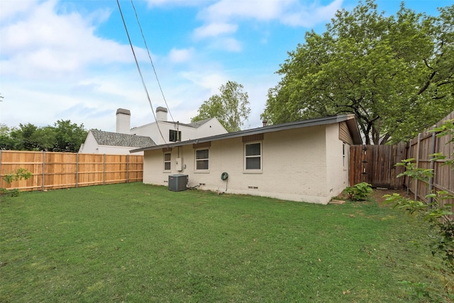 back of property featuring a lawn, cooling unit, a fenced backyard, and brick siding