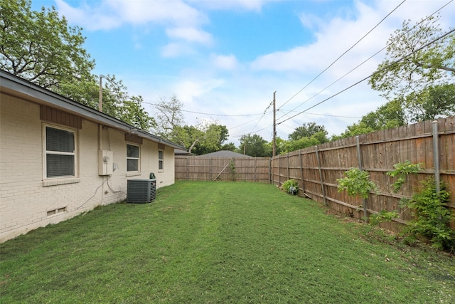 view of yard with a fenced backyard and central AC