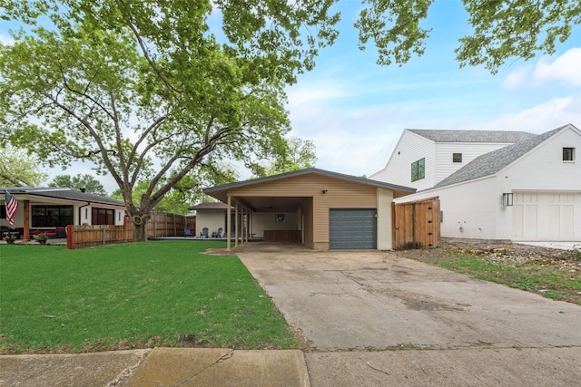 view of front facade featuring a front lawn, fence, driveway, and a carport