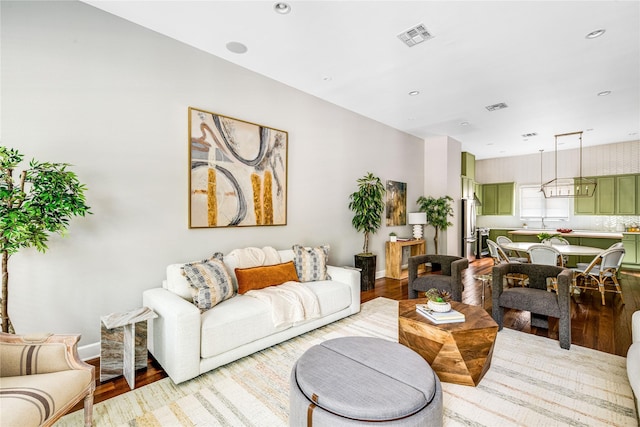 living room with visible vents, baseboards, and light wood-type flooring