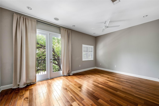 unfurnished room featuring a ceiling fan, baseboards, visible vents, and hardwood / wood-style floors