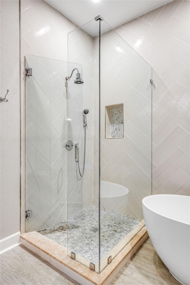 bathroom featuring a freestanding bath and a shower stall