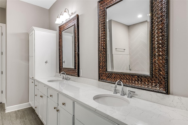 bathroom with a sink, baseboards, and double vanity