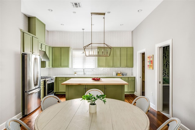kitchen featuring under cabinet range hood, stainless steel appliances, visible vents, and green cabinets