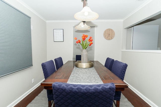 dining space featuring baseboards, ornamental molding, and wood finished floors