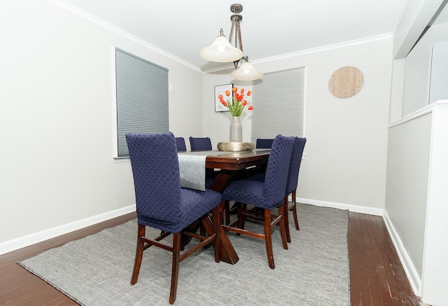 dining space with crown molding, wood finished floors, and baseboards