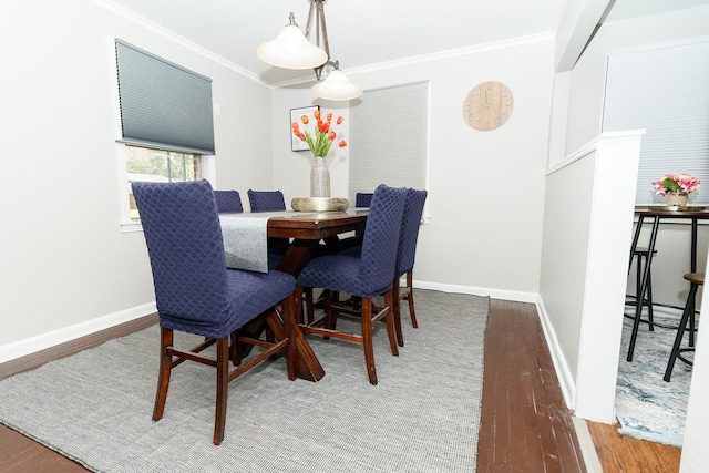 dining area with crown molding, baseboards, and wood finished floors