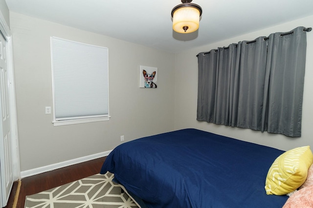 bedroom with baseboards and wood finished floors