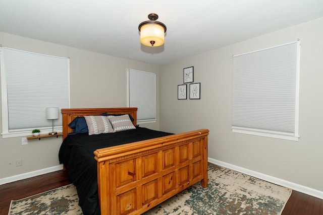 bedroom with baseboards and wood finished floors