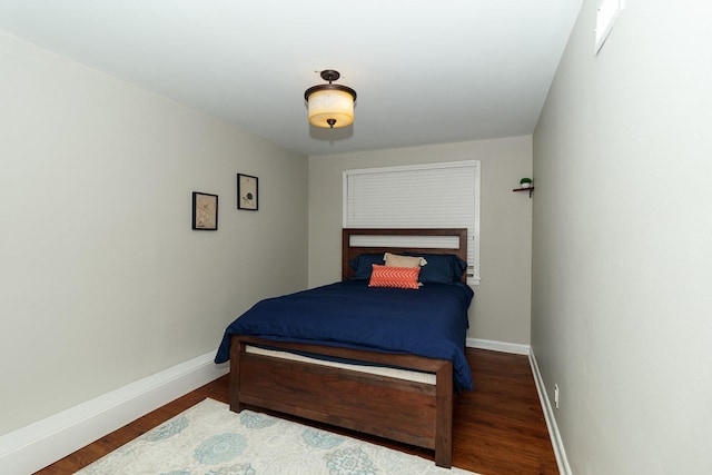 bedroom featuring baseboards and wood finished floors